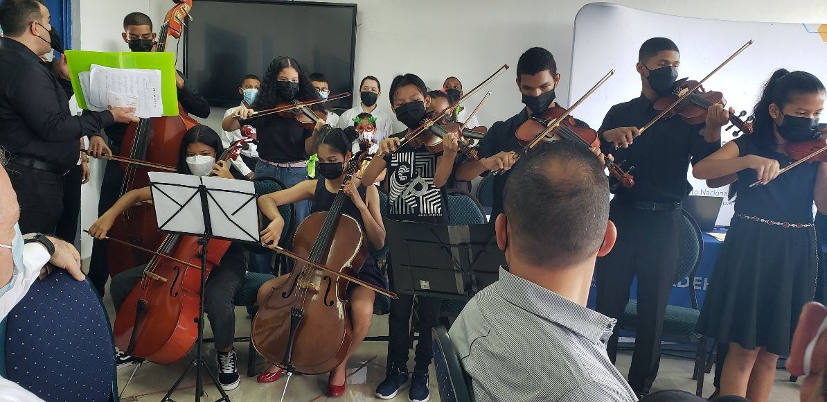 Agrupación de cuerdas de niños tocando en el acto de INADEH El Chorrillo.
